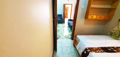 a bedroom with a door open to a room with two beds at Goodhope 3-Bedroom Vacation Rental in Arusha