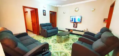 a living room with two couches and a flat screen tv at Goodhope 3-Bedroom Vacation Rental in Arusha
