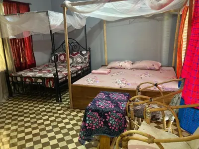a bedroom with two bunk beds and a chair at Lake Natron Maasai Guesthouse in Mtowabaga