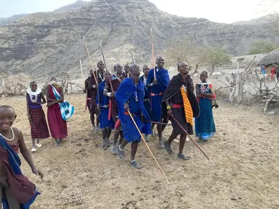 a group of people standing in front of a mountain at Lake Natron Maasai Guesthouse in Mtowabaga