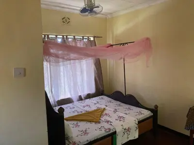 a small bedroom with a bed and a window at Lake Natron Maasai Guesthouse in Mtowabaga