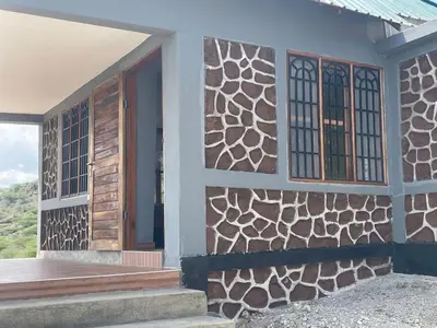 a house with a wooden door and windows at Lake Natron Maasai Guesthouse in Mtowabaga