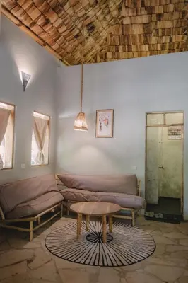a living room with couches and a table at The Jungle Pearl Resort in Mto wa Mbu