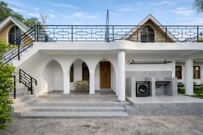 a white house with a staircase leading up to it at Toiwo Residence Arusha in Arusha