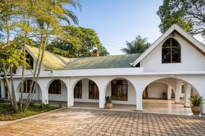 an old white building with a tiled courtyard at Toiwo Residence Arusha in Arusha