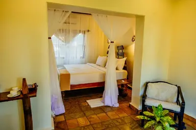 a bedroom with a bed and a window at Weru Weru River Lodge in Moshi