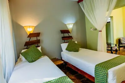 a room with two beds in a room at Weru Weru River Lodge in Moshi