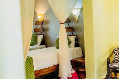 a bedroom with a bed with a canopy at Weru Weru River Lodge in Moshi