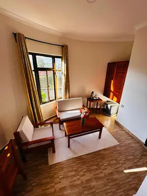 a living room with a couch and a coffee table at Wademac Arusha Inn Hotel in Arusha