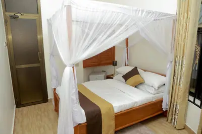 a bedroom with a bed with a canopy at Wademac Arusha Inn Hotel in Arusha