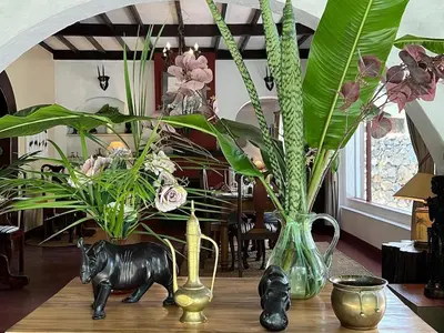 a table with vases and a statue of a gorilla and flowers at Mount Meru Game Lodge in Arusha