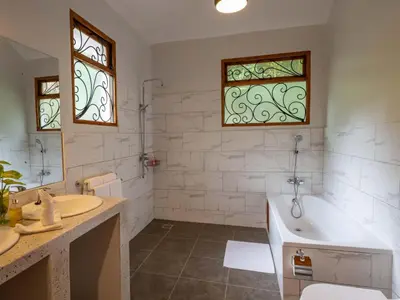 a bathroom with a tub and a sink at Mount Meru Game Lodge in Arusha