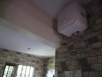 a bathroom with a shower with a stone wall at Darema Homestay in Arusha