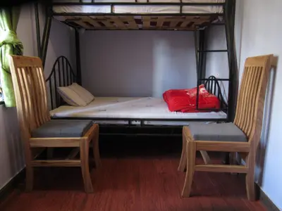 a bunk bed with two chairs and a red blanket on it at Darema Homestay in Arusha