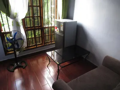 a living room with a couch and a table and a window at Darema Homestay in Arusha