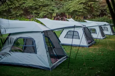a row of tents sitting in the grass at Shose Farmhouse Chalets & Campsite in Moshi