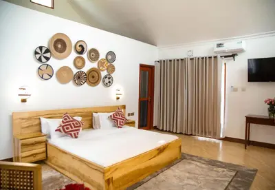 a bedroom with a bed with plates on the wall at Shose Farmhouse Chalets & Campsite in Moshi