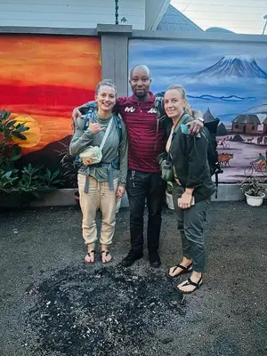 a man and two women standing in front of a painting at Safari villa in Arusha
