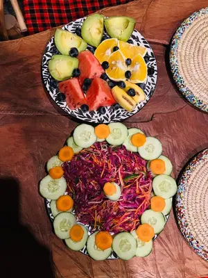 two plates of food on a wooden table at Safari villa in Arusha