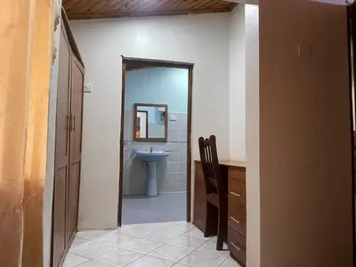 a bathroom with a sink and a toilet and a mirror at Joe & El Heritage Villa in Mwika