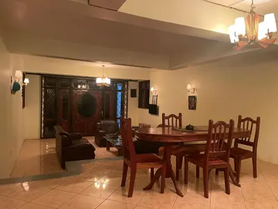 a dining room with a wooden table and chairs at Joe & El Heritage Villa in Mwika