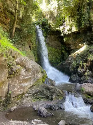 a waterfall on the side of a mountain with rocks at Joe & El Heritage Villa in Mwika