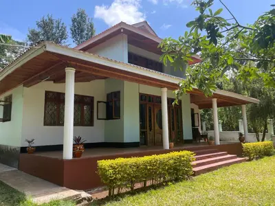 a house with a porch and columns at Joe & El Heritage Villa in Mwika