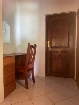 a wooden desk with a chair next to a door at Joe & El Heritage Villa in Mwika