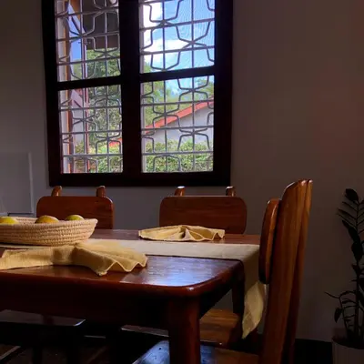 a dining room with a table and a stained glass window at Goodtimewithfar House in Moshi