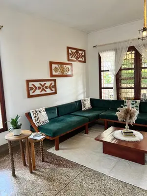 a living room with a green couch and a table at Goodtimewithfar House in Moshi