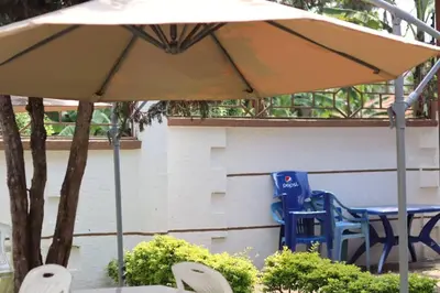 a table and chairs under an umbrella in a yard at Otakef Motel in Arusha
