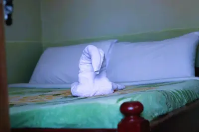 a bed with a pair of white boots on it at Otakef Motel in Arusha