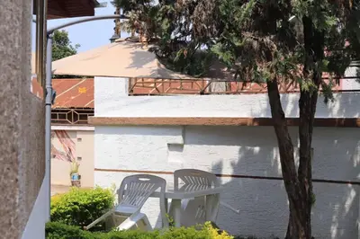 two chairs and a table next to a tree at Otakef Motel in Arusha